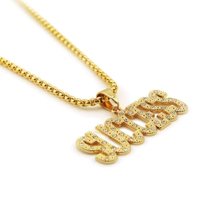 Macro shot of gold-plated GUESS letter pendant encrusted with sparkling cubic zirconia