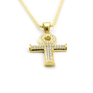 Gros plan détaillé du pendentif croix Ankh doré serti de strass étincelants