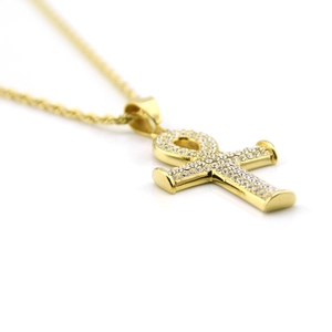 Gros plan d'un pendentif Ankh doré orné de strass brillants et d'une chaîne torsadée