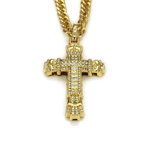 Detailed macro view of iced-out gold cross pendant with cubic zirconia on cuban link chain