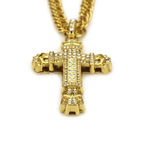 Macro shot of gold hip hop cross pendant with cubic zirconia and thick cuban chain