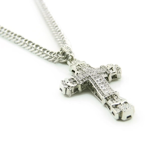Close-up of hip hop silver cross pendant with sparkling crystals on cuban link chain