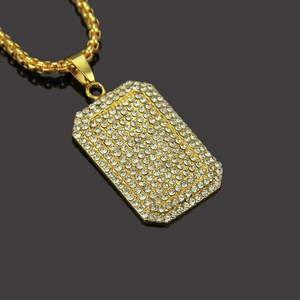 Hip-Hop-Halskette mit eisigem Anhänger und goldener Kette auf dunkel gespiegeltem Grund
