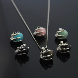 Detailed view of punk dragon claw pendants holding various colorful natural stone spheres