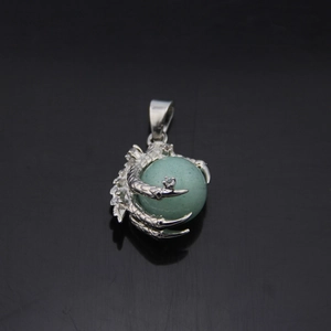 Retro dragon claw pendant with rotating green natural stone on black background