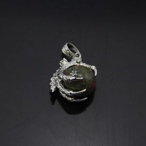 Detailed view of dragon claw pendant holding a round unakite stone in silver finish