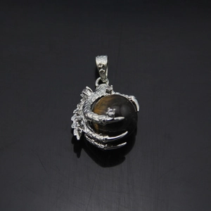 Detailed view of silver dragon claw pendant with rotating tiger eye stone sphere