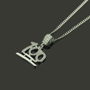Dettaglio del ciondolo hip hop in argento con numero 100 e strass scintillanti