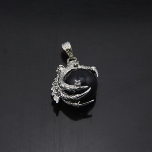 Detail of a punk dragon claw pendant holding a dark blue sandstone sphere with silver finish