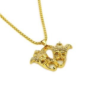 Detail of gold hip hop necklace featuring iced-out double drama clown mask pendant