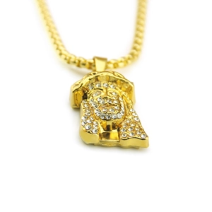 Close-up of hip hop Jesus head pendant with white rhinestones on gold bead chain