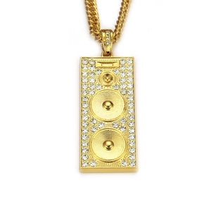 Macro view of gold speaker pendant with rhinestones on a chunky cuban chain