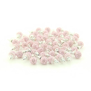 Macro view of sparkling pink crystal ball stud earrings with polished metal needles