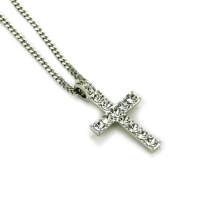 Détail du pendentif croix argenté avec cristaux sur une chaîne à maillons cubains