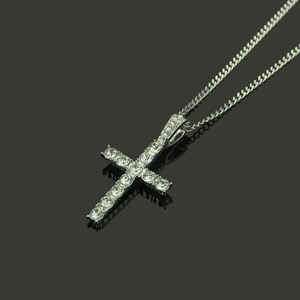 Vue macro d'un pendentif croix hip hop argenté avec zircons sur une chaîne cubaine