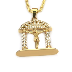 Détail macro du pendentif crucifix plaqué or avec zircons cubiques et chaîne de corde