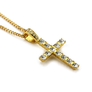 Gros plan détaillé du pendentif croix dorée serti de zircons sur une chaîne à maillons