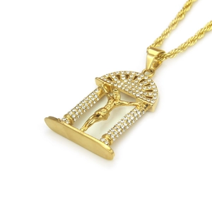 Détail d'un pendentif crucifix doré orné de strass blancs sur une chaîne corde