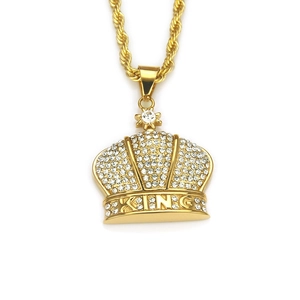 Detailed macro shot of the iced-out golden crown pendant featuring KING embossed lettering