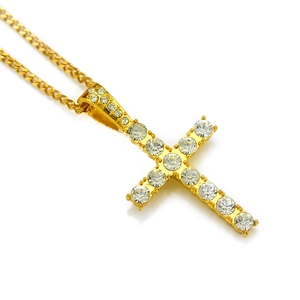 Dettaglio del ciondolo a croce dorata hip hop con strass brillanti e catena cubana