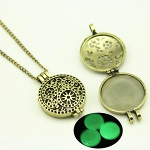 Detail showing the bronze gear locket necklace with green luminous stone glow
