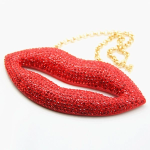 Close-up of red rhinestone oversized lips evening bag with elegant gold metal chain