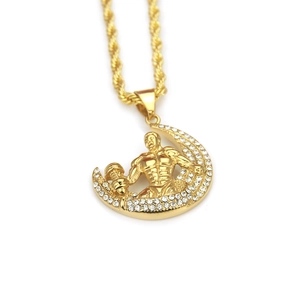 Détail du pendentif haltère doré avec strass scintillants et chaîne à maillons torsadés