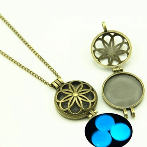 Detail of vintage bronze hollow flower pendant necklace showing blue luminous glow effect
