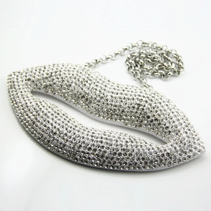 Close-up of oversized red lip pendant with sparkling crystals on a silver link chain