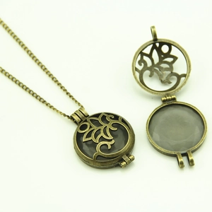 Detailed view of hollow vintage bronze circular locket with intricate leaf carving design