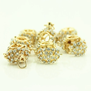 Close-up of golden hollow spheres with crystal rhinestones for DIY necklace jewelry making