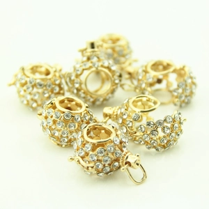 Detailed macro view of golden hollow sphere pendants with sparkling crystals for DIY jewelry