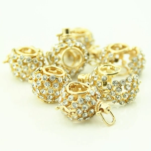 Close-up of golden hollow rhinestone ball charms for DIY necklace and jewelry making