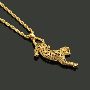 Vue macro du pendentif léopard plaqué or avec pierres noires sur une chaîne de corde