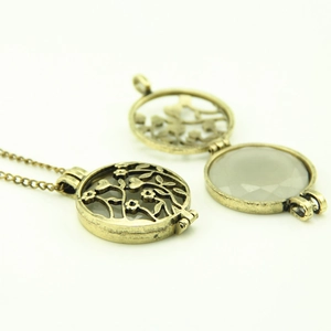 Vintage hollow luminous locket necklace with bronze floral design and grey crystal