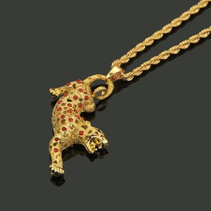 Gros plan du pendentif léopard hip-hop avec strass rouges et chaîne torsadée dorée