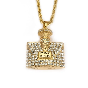 Nahaufnahme von goldener Parfümflasche-Anhänger mit Strasssteinen und Kordelkette