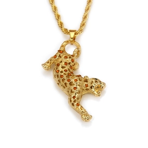 Détail du pendentif léopard doré avec strass orange et yeux en cristal vert