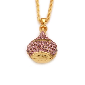 Détail du pendentif flacon de parfum doré avec strass roses et gravure PARFUM