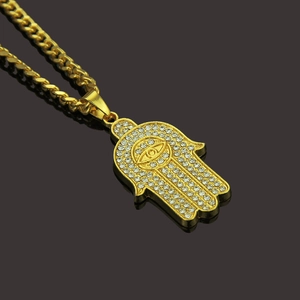 Gold Hamsa Hand pendant necklace with evil eye and crystals on a Cuban chain