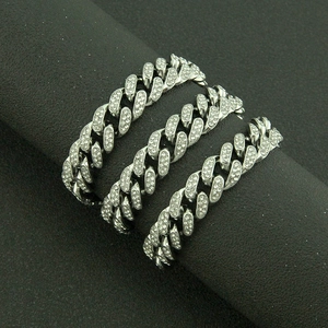 Détail de trois bracelets maille cubaine argentés sertis de strass sur un présentoir