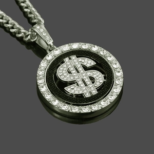Dettaglio del ciondolo a segno di dollaro con zirconi su catena a maglia cubana argento