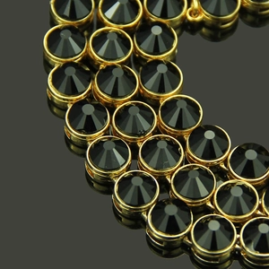 Macro detail of luxury gold chain with round black faceted crystals and link structure