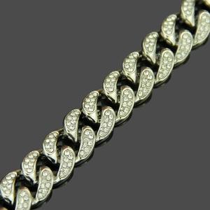 Macro shot of iced out Cuban link chain with silver plated metal and sparkling rhinestones