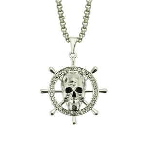 Détail d'un pendentif tête de mort punk argenté avec gouvernail et pierres zircone