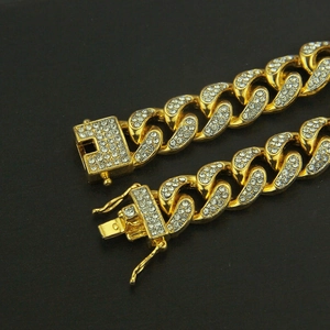 Macro shot of 18k gold plated Cuban link chain with pave setting diamonds and safety buckle