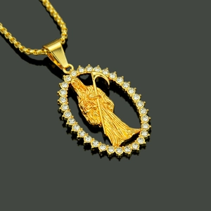 Close-up of gold hip hop pendant featuring a Grim Reaper figure with sparkling crystals