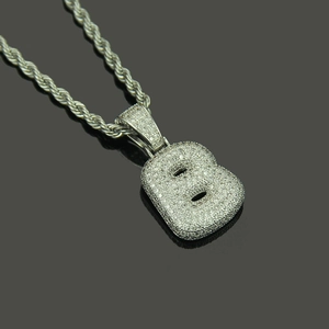Macro shot of silver hip hop bubble letter B pendant with micro-paved cubic zirconia
