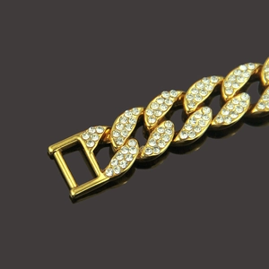 Gros plan d'une gourmette cubaine dorée sertie de strass brillants au style hip hop