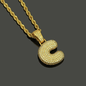 Macro detail of gold Hip Hop letter C pendant with micro-paved cubic zirconia stones